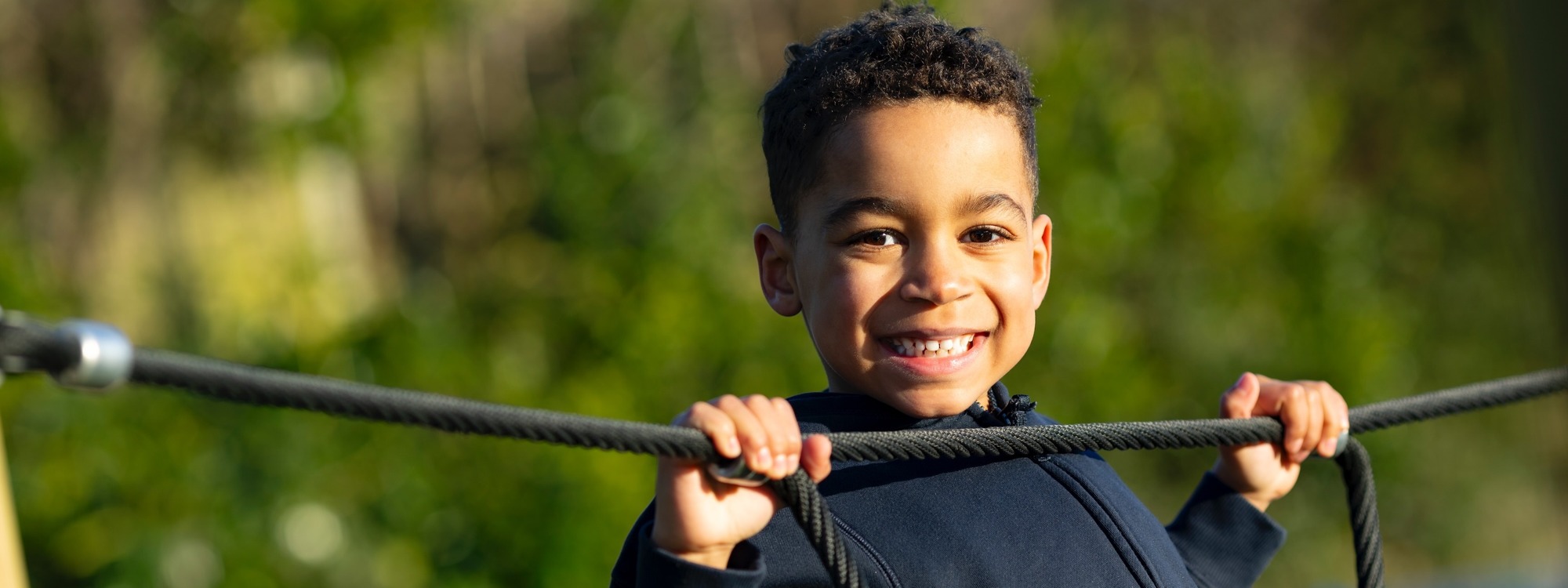 Lickey Hills School pupil outside looking happy on climbing rope